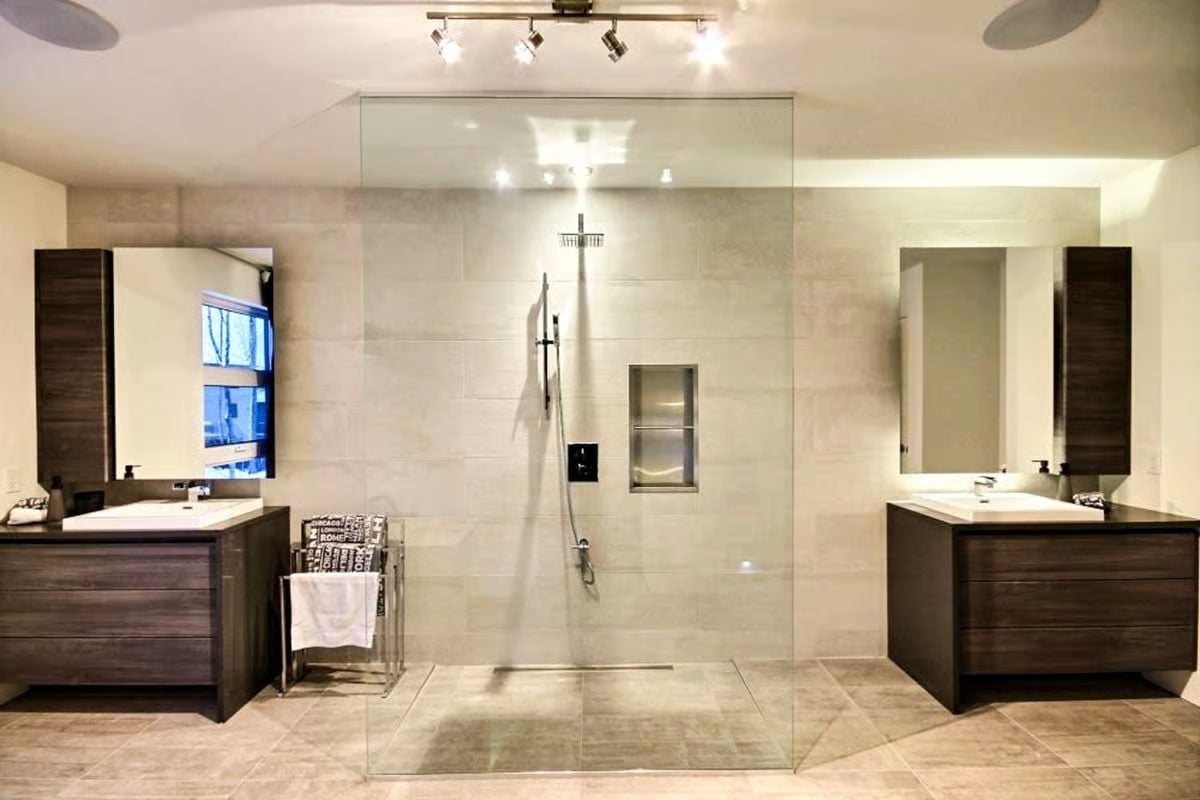 Dual Vanities Flanking a Walk-In Glass Shower Is the Master Bath Formula That Actually Scales