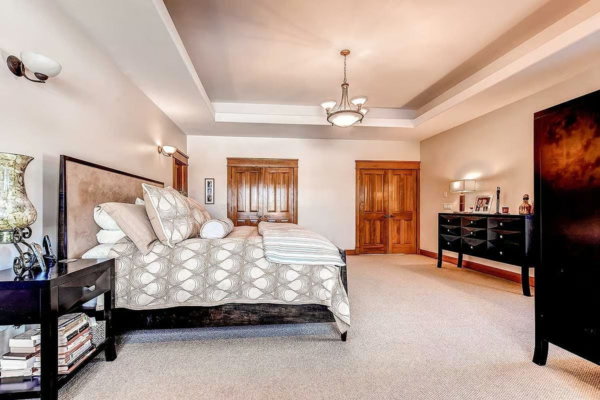 Tray Ceiling and Dark Wood Furniture Make This Primary Bedroom Feel Earned