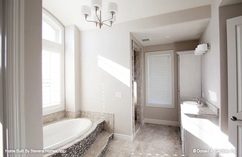Pebble Tile Steps, Soaking Tub, and Natural Light That Does the Heavy Lifting