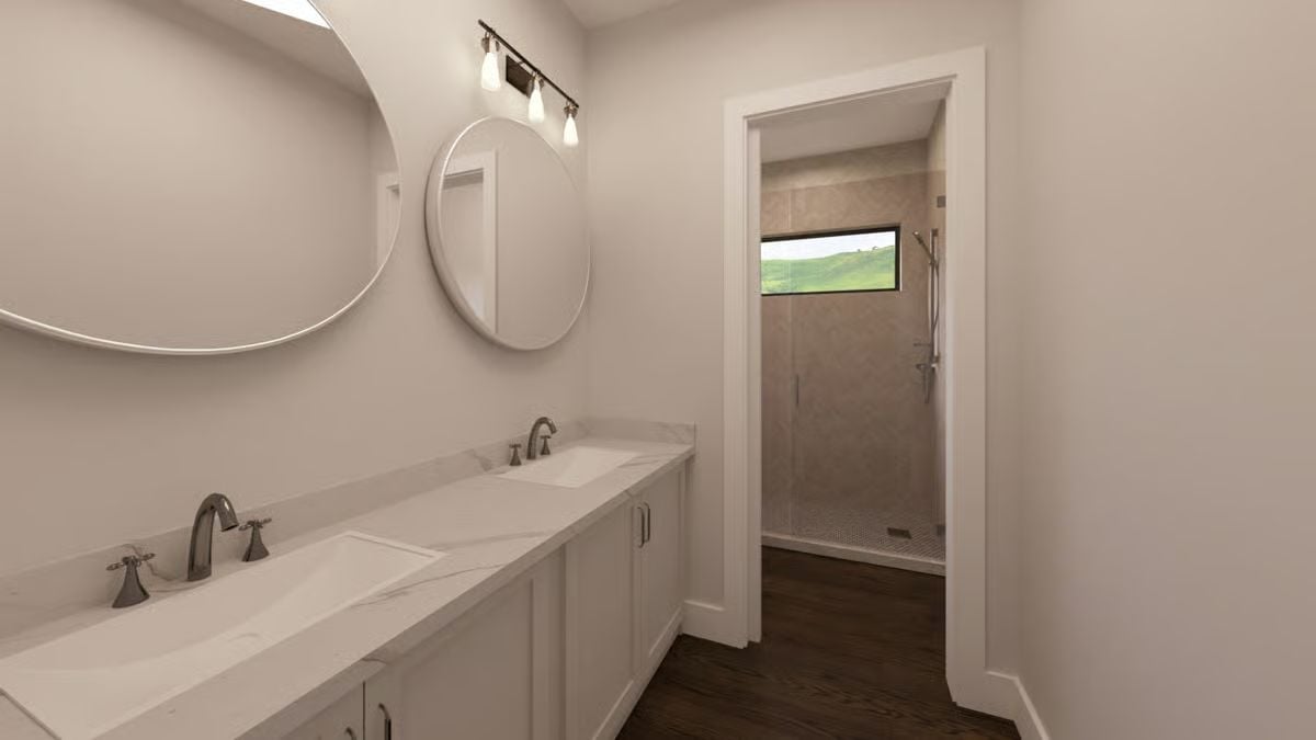 Double Vanity Where Round Mirrors and Marble Countertops Split the Work Evenly