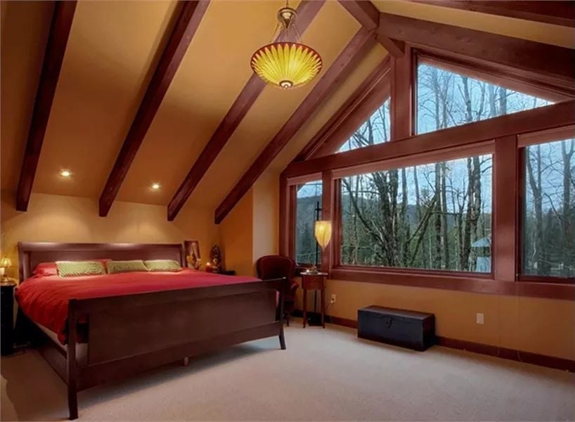 Cathedral Ceiling and Red Bedding Turn a Forest View Into Something You'd Stay In All Day