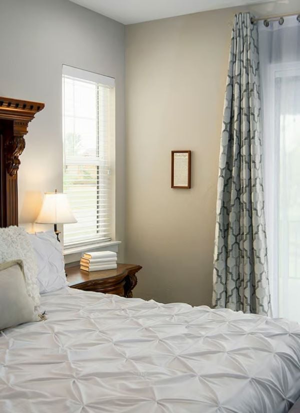 Pinch-Pleated Bedding and Dark Wood Trim Earn Their Place Here