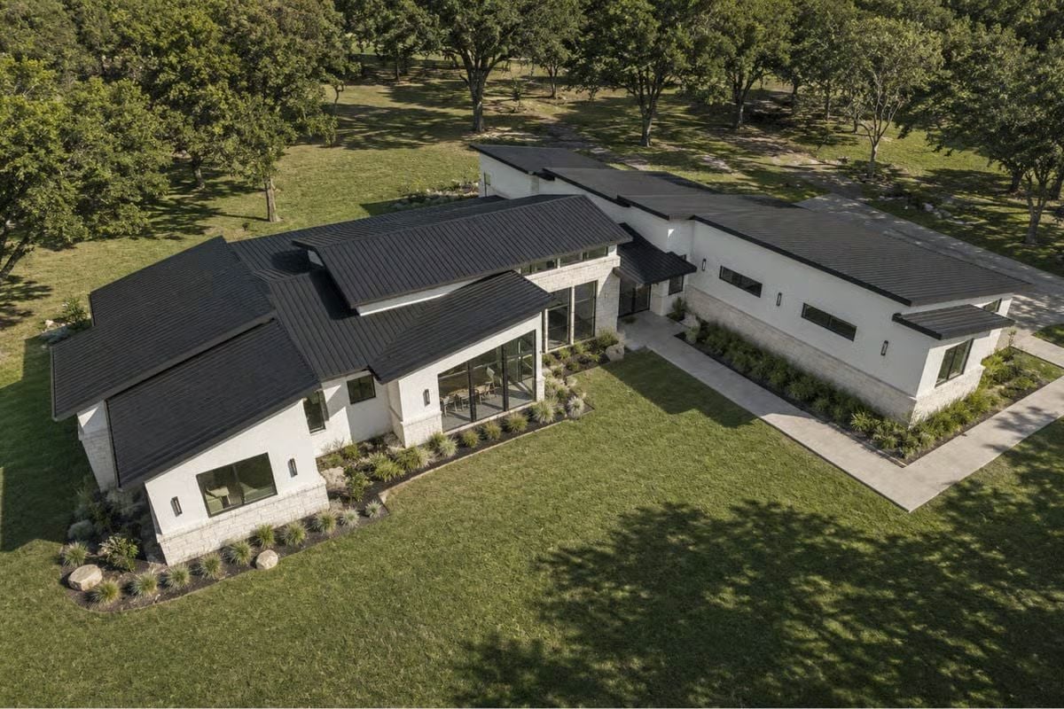 Dark Metal Roofline Over White Stone, Designed to Sit Low in the Trees