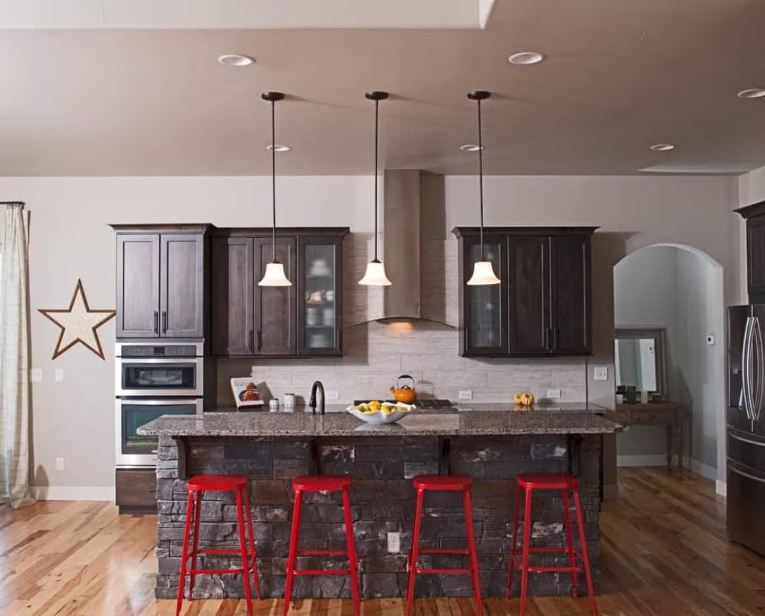 Red Stools Against Stone Make Every Other Kitchen Feel Boring
