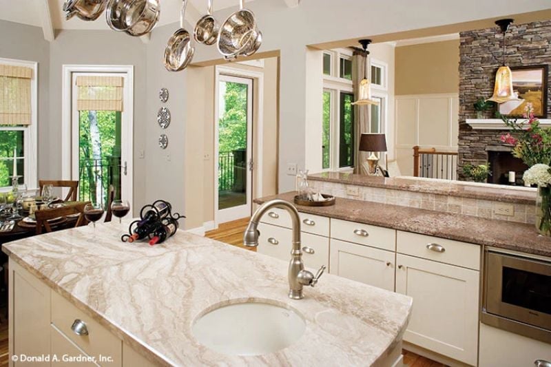 Pot Rack Overhead, Marble Below, and a Sink That Anchors the Whole Island