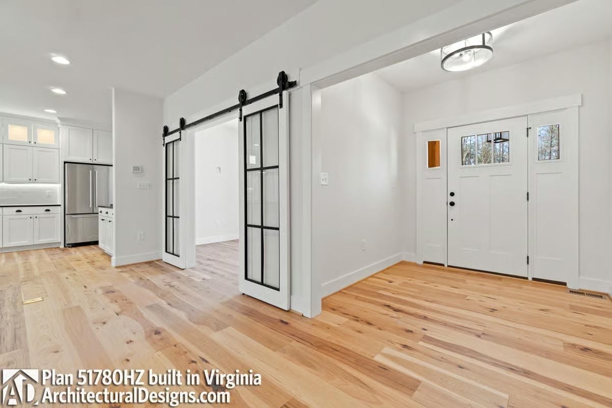 Black Steel Barn Doors Pull Double Duty Between the Kitchen and Entry