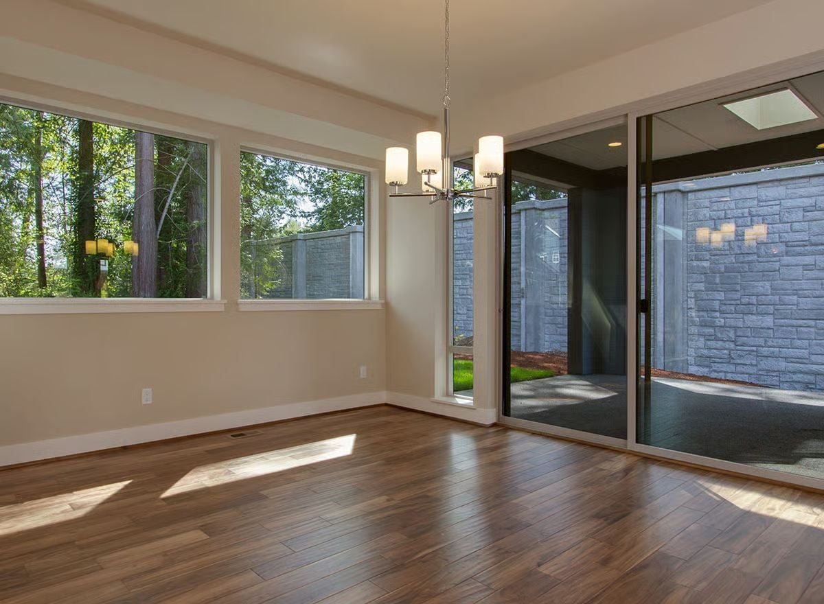 Hardwood, Chandelier, and Sliding Glass That Opens to a Stone Courtyard