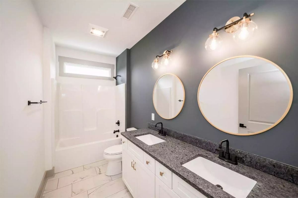 Gold-Framed Mirrors and Matte Black Fixtures Doing the Heavy Lifting in This Double Vanity