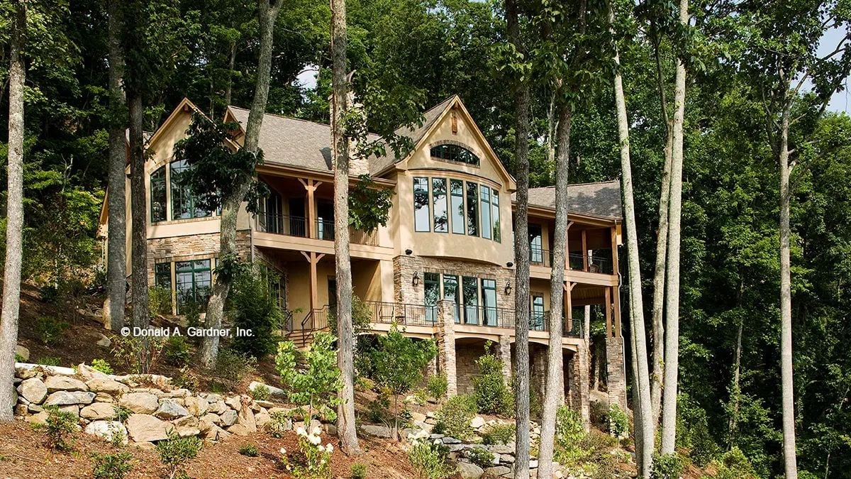 Stone, Glass, and Tall Trees: This Walkout Rear Elevation Earns Its Views