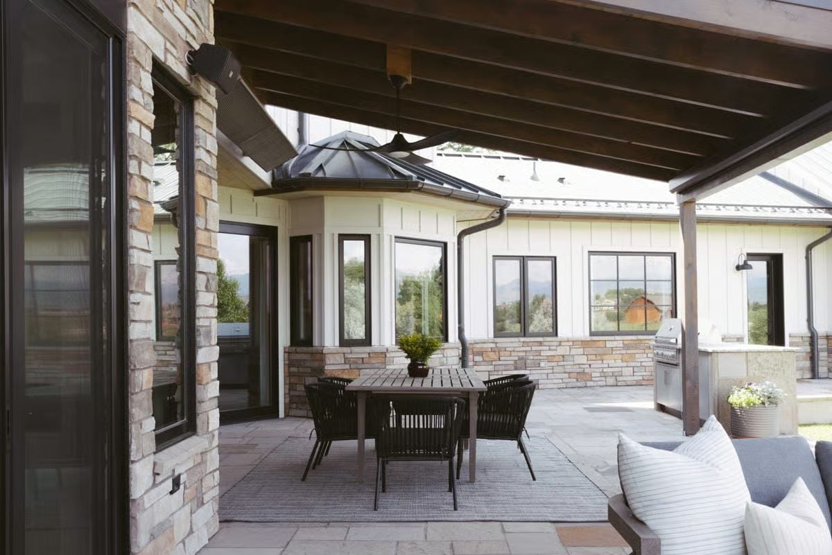 Covered Patio With Exposed Beams and Stone Columns Earns Year-Round Use