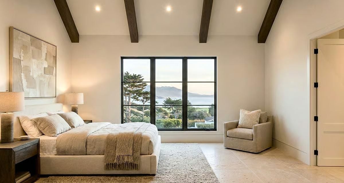 Dark Ceiling Beams, Ocean Light, and a Bedroom That Earns Its Quiet