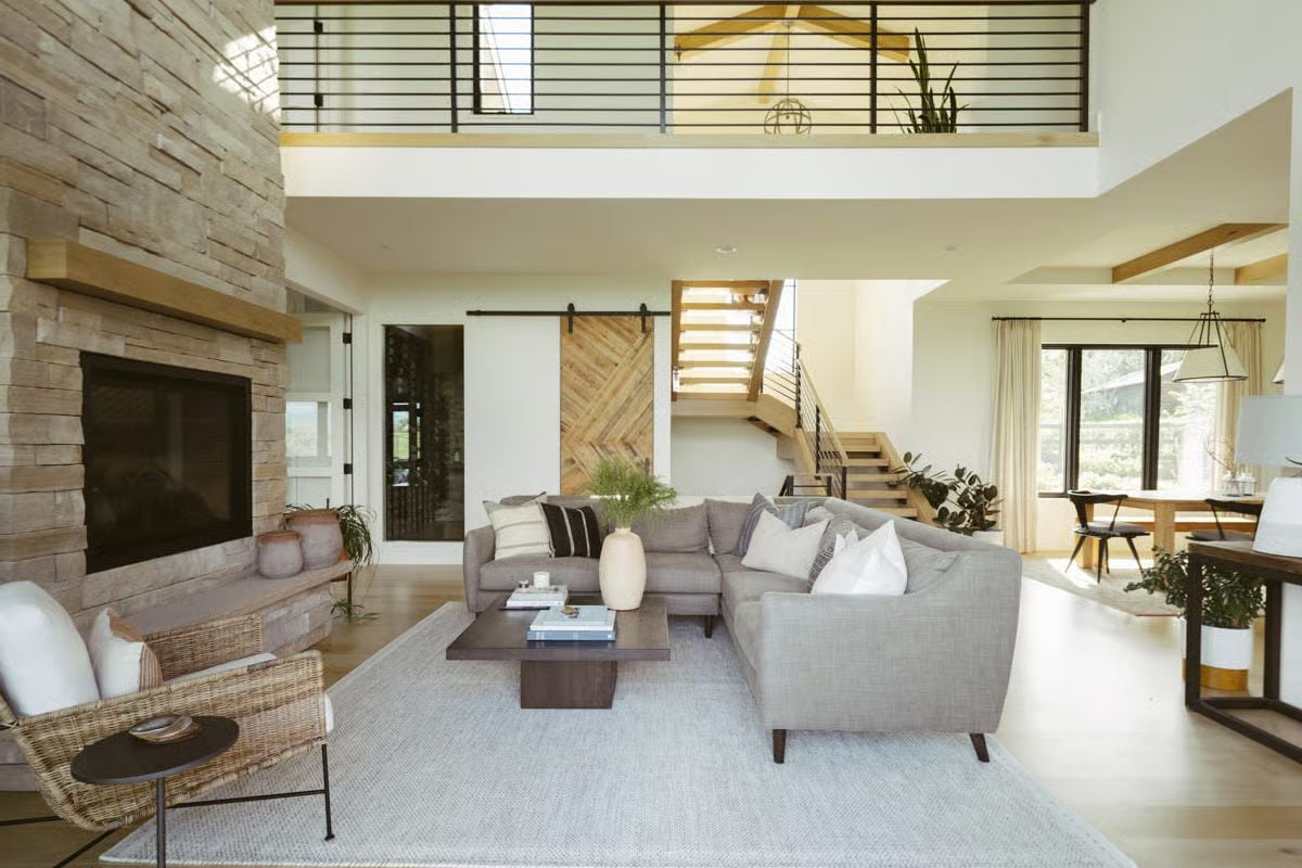 Double-Height Ceilings and a Stone Fireplace Wall Anchor the Living Space