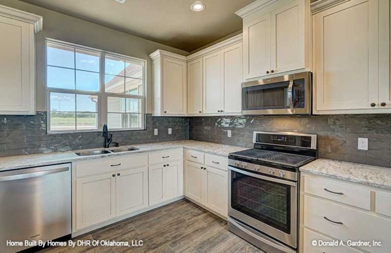 Cream Cabinets and Stone Backsplash Do the Heavy Lifting in This Kitchen