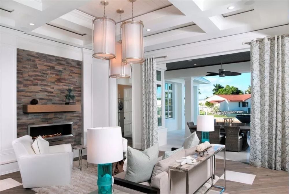 Stacked Pendant Cylinders Over a Living Room That Earns Its Fireplace