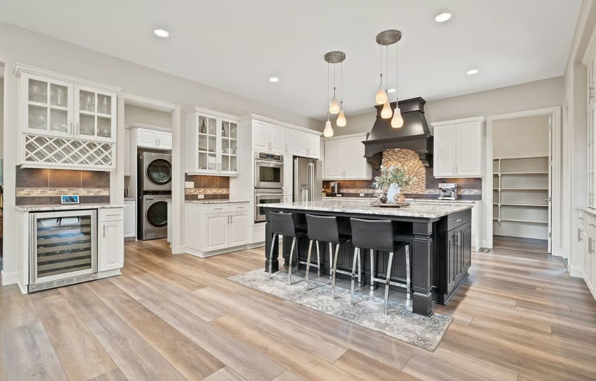 Dark Island, White Cabinets, and a Wine Fridge That Earns Its Square Footage