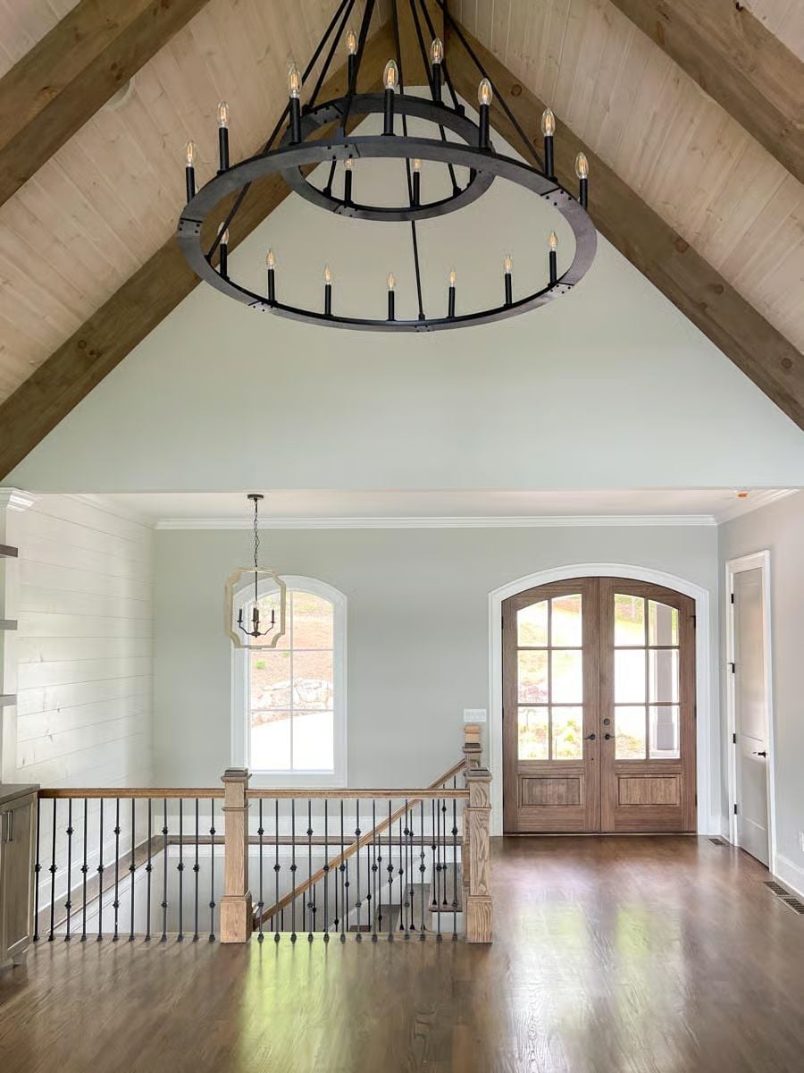 Vaulted Foyer with Exposed Trusses and a Chandelier Built for the Scale