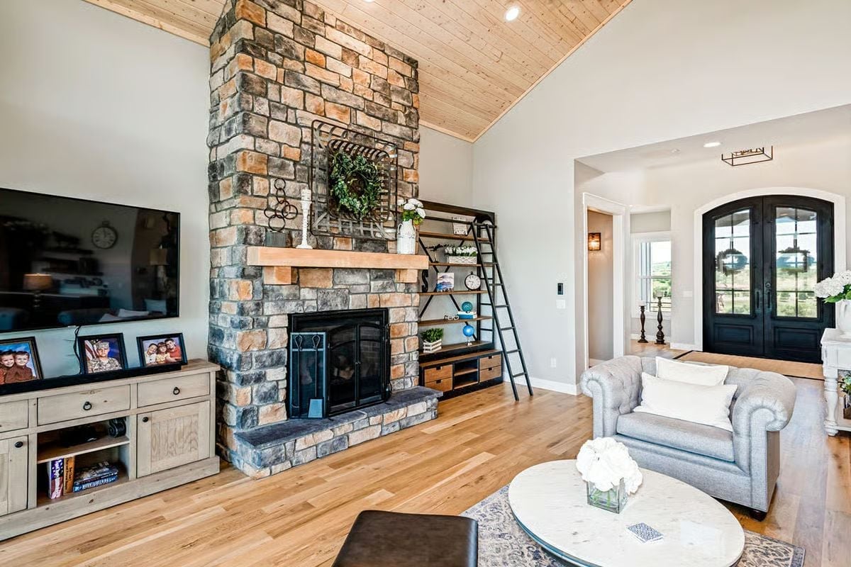 Floor-to-Ceiling Stone Fireplace Anchors a Living Room Built Around Real Life