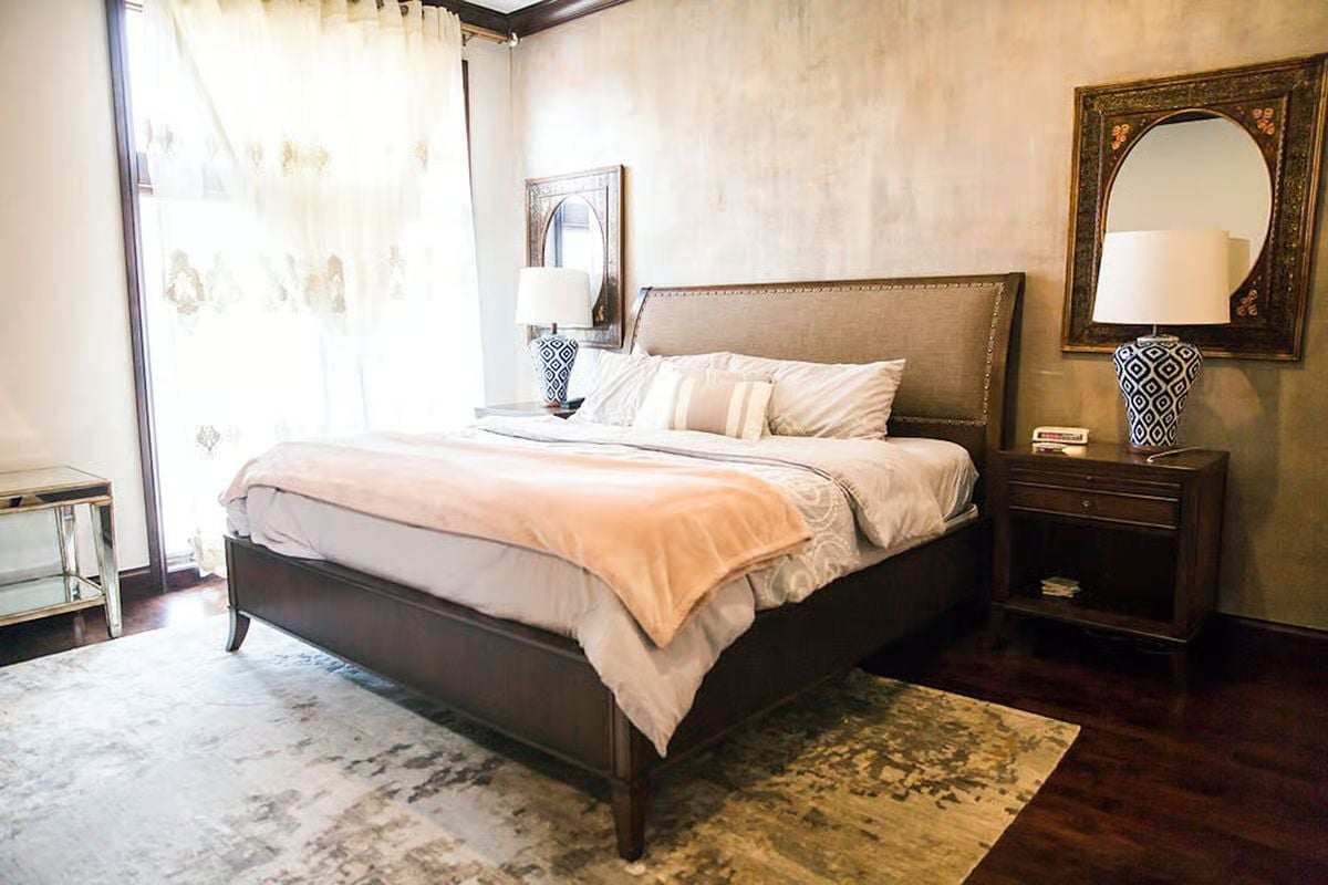 Upholstered Headboard With Nailhead Trim in a Room Built Around Earned Comfort