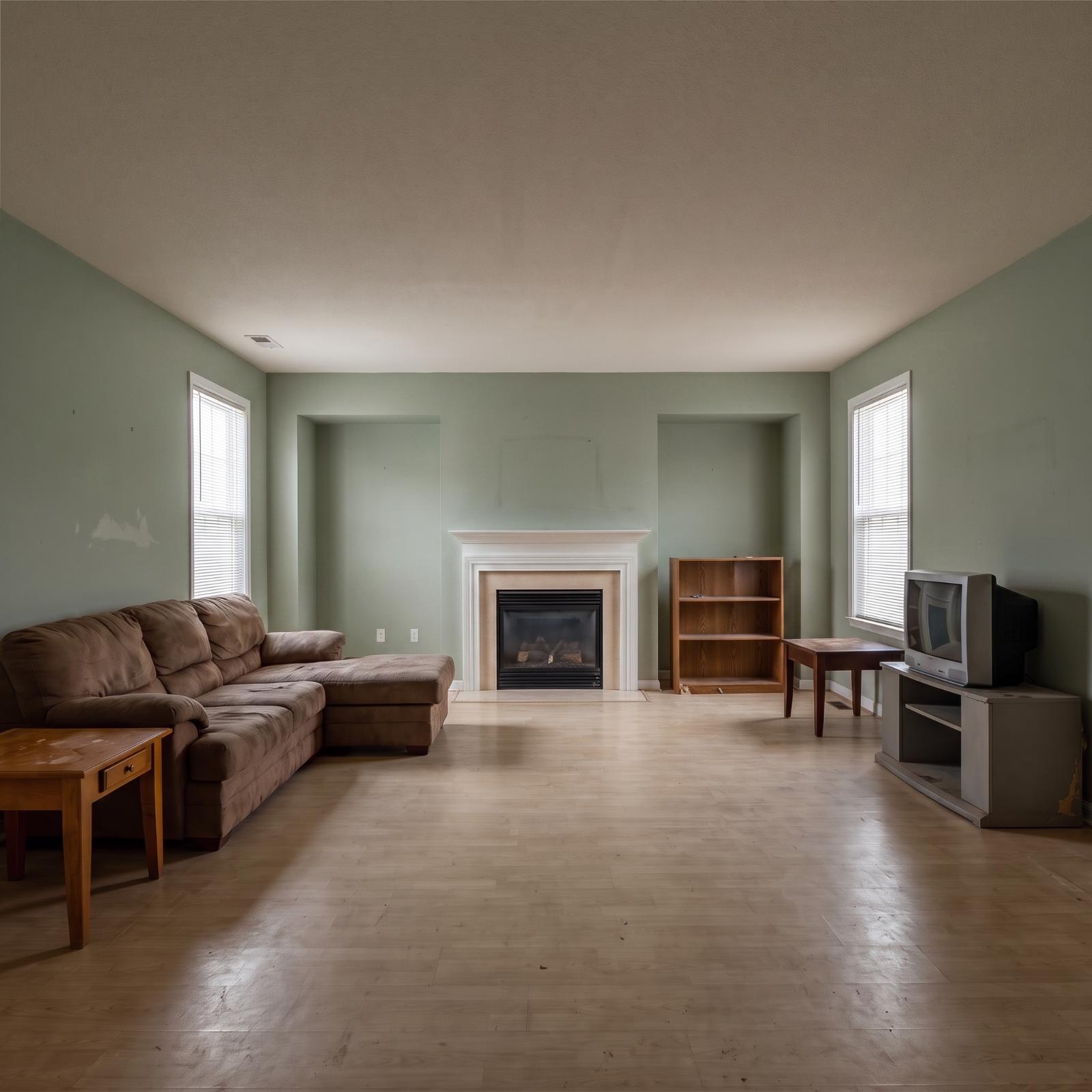 Large empty-nest family room reimagined in cream, brown, stone, leather, and natural wood