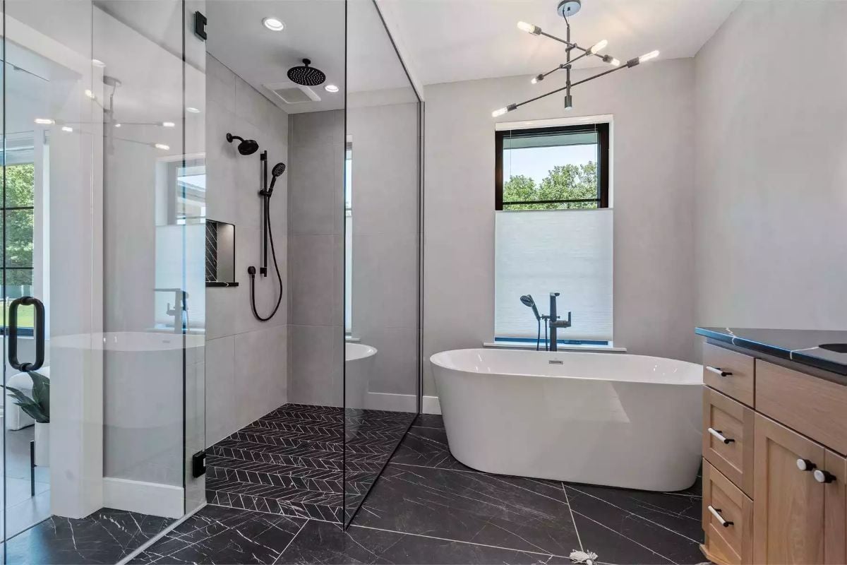 Freestanding Soaker Tub and Herringbone Shower Floor Do the Heavy Lifting Here