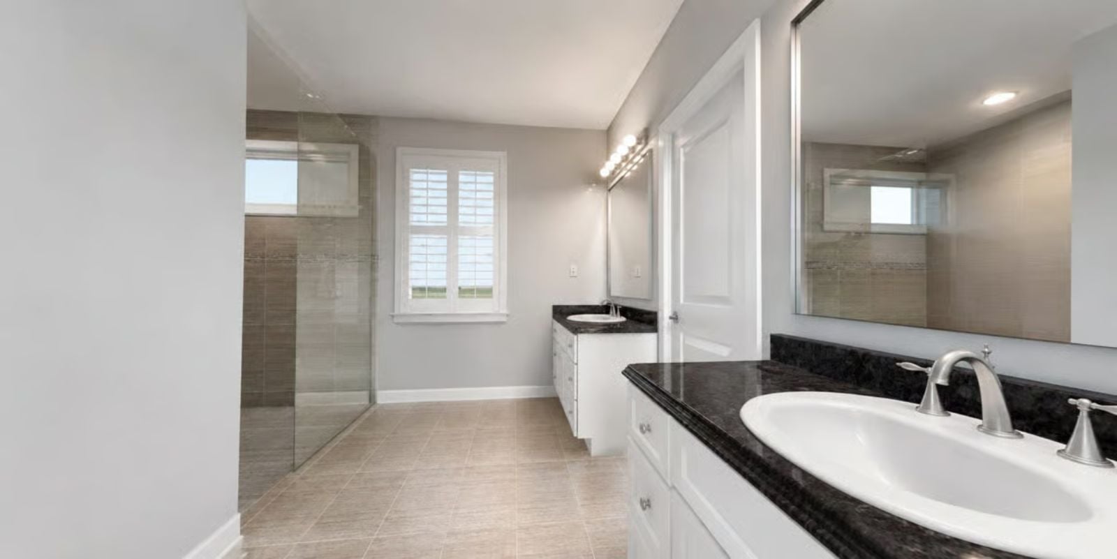Dual Vanities, Dark Granite, and a Glass Shower That Earns Its Square Footage