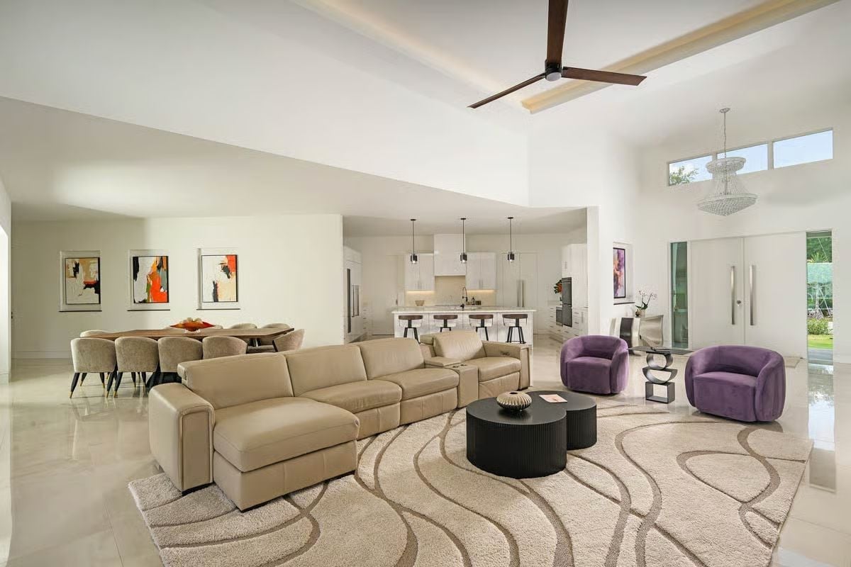 Beige Leather Sectional and Purple Velvet Chairs in an Open-Plan Living Space
