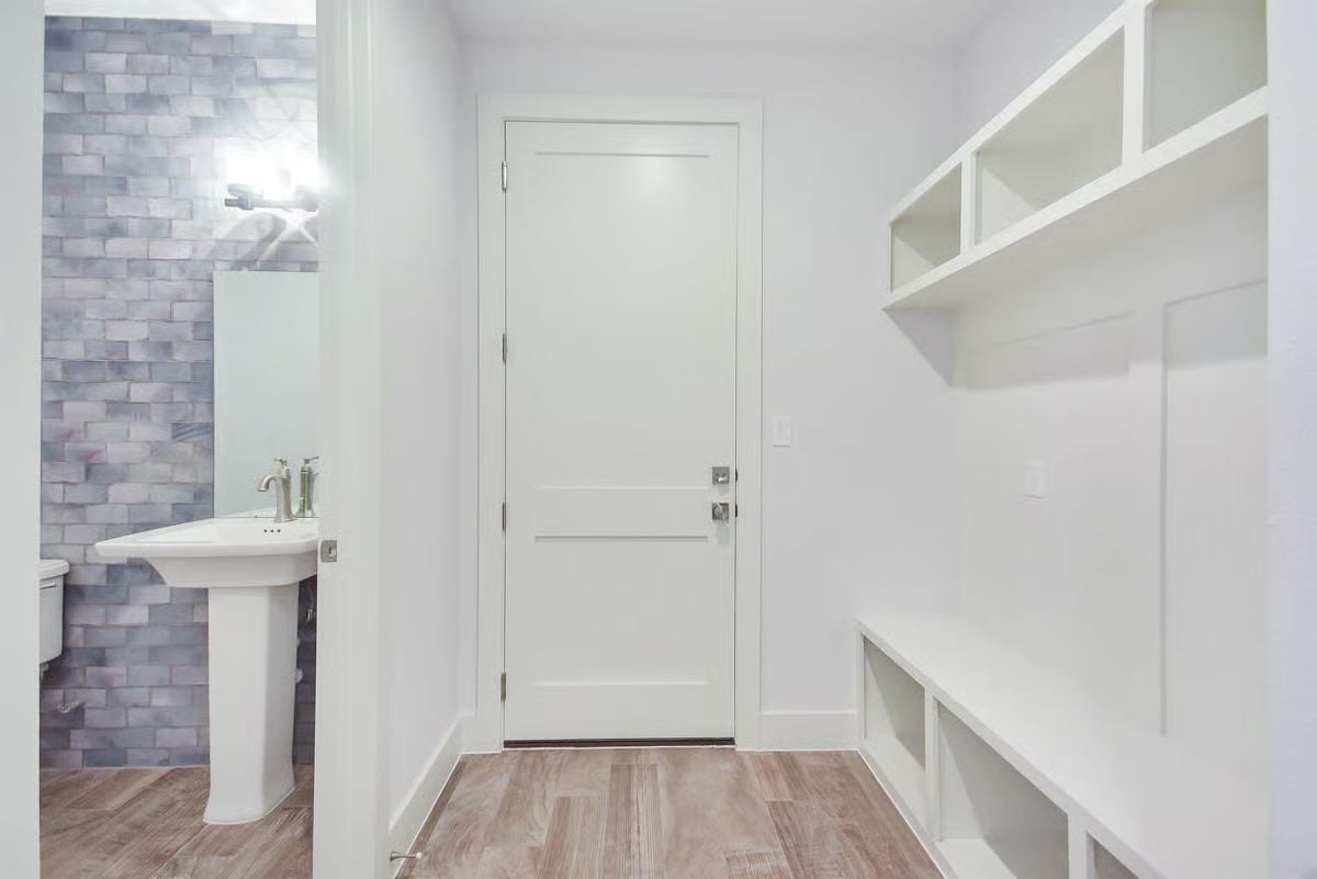 Mudroom Built for Real Life Sits Steps From a Half Bath That Pulls Its Weight