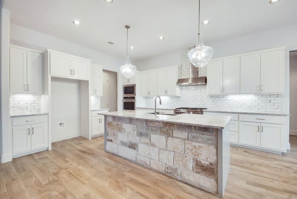 Stone-Clad Island Base Earns Its Place in a Kitchen Full of White