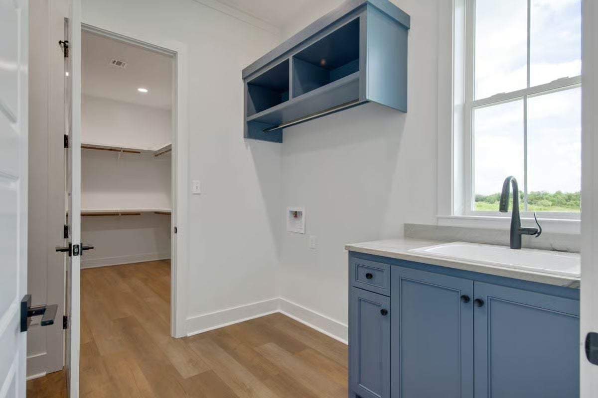 Blue Cabinetry, a Utility Sink, and a Closet Door That Makes This Room Work Harder