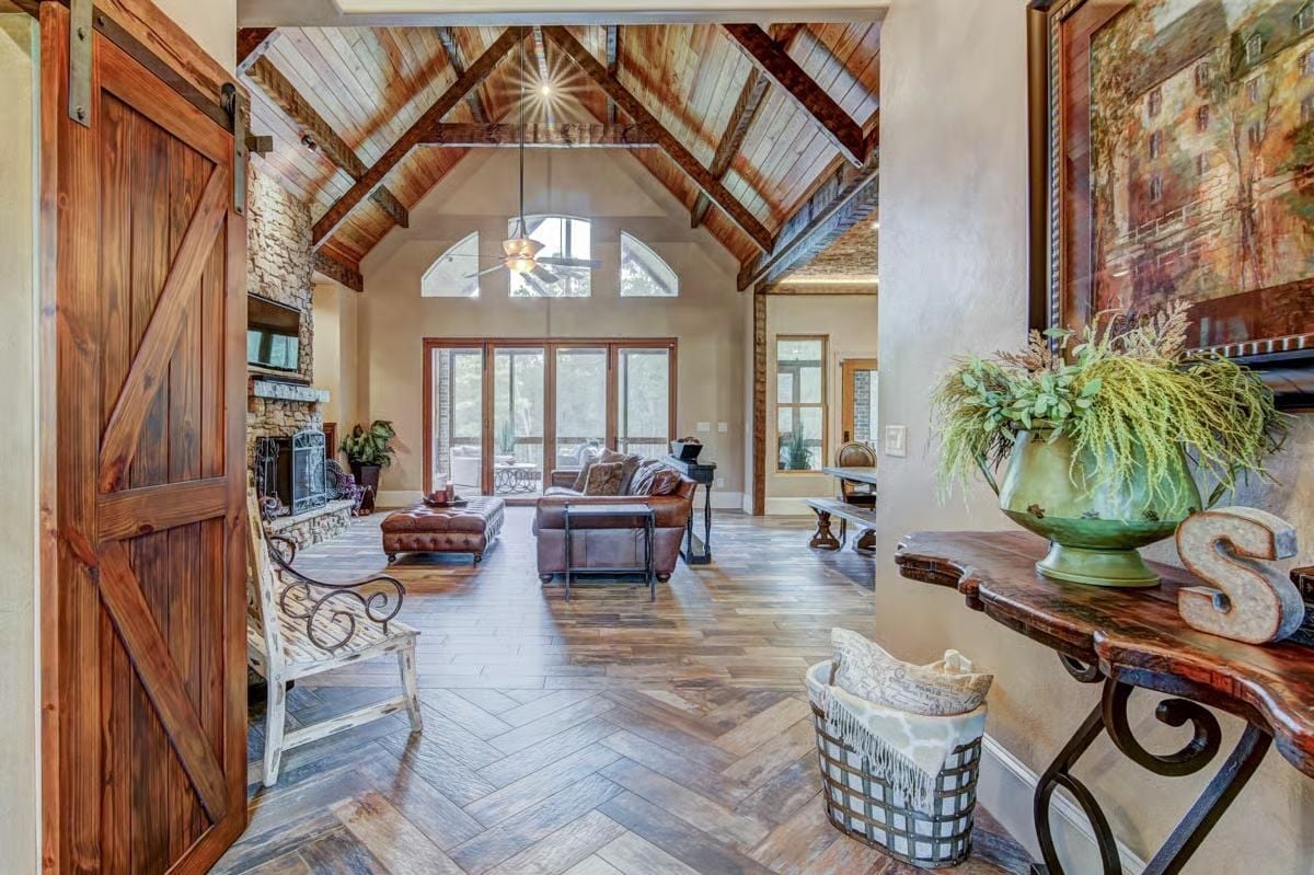 Vaulted Entry with Barn Door and Exposed Timber Trusses Sets the Tone Early