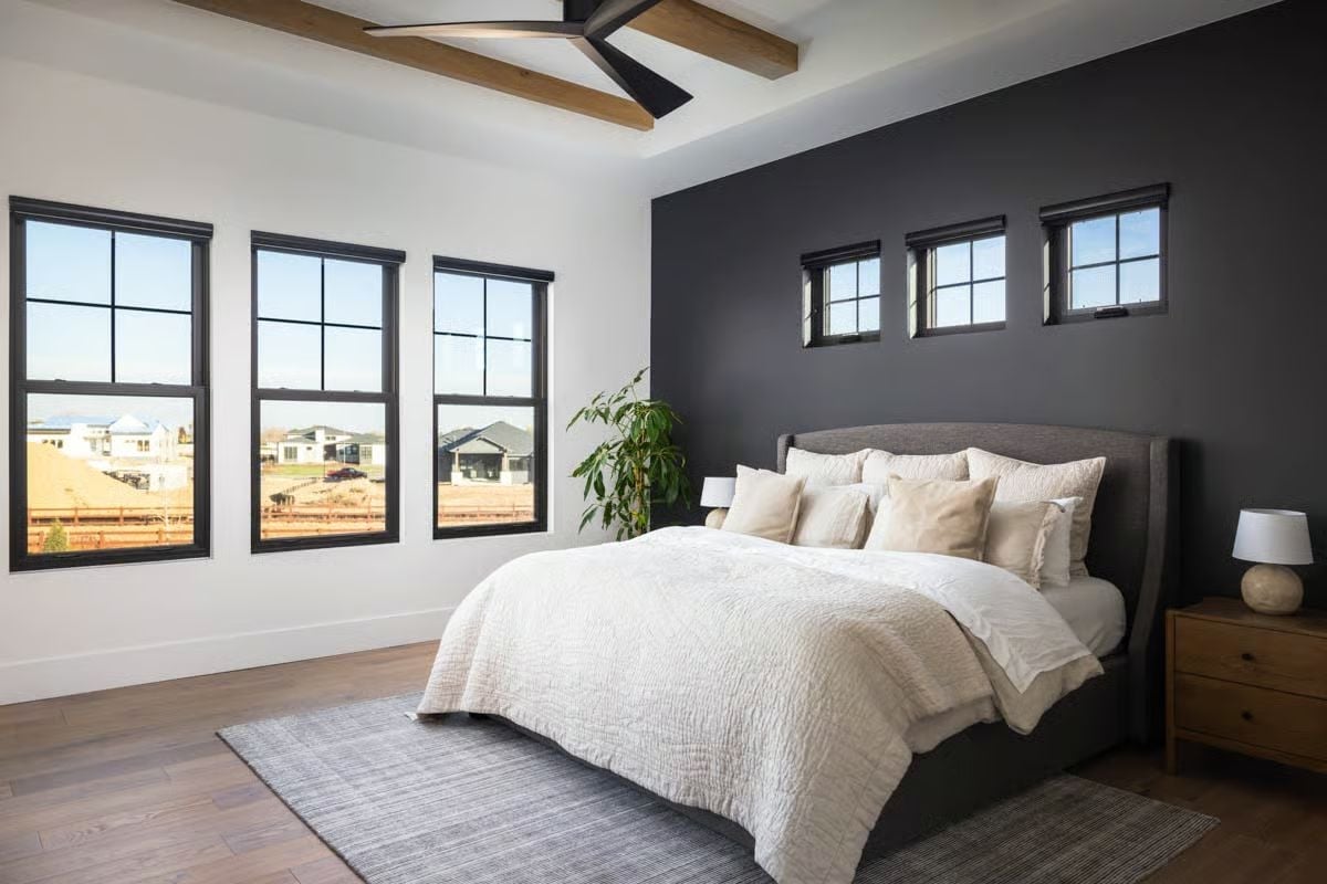 Dark Accent Wall and Warm Wood Tones Make This Primary Bedroom Feel Grounded