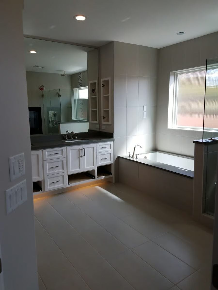 Toe-Kick Lighting and a Drop-In Tub Tucked Against Tile Do the Heavy Lifting Here