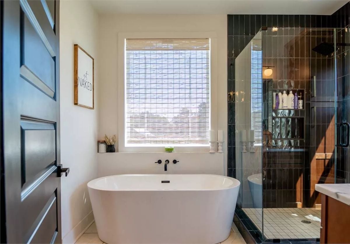 Freestanding Tub, Black Tile, and a Sign That Sets the Tone Immediately