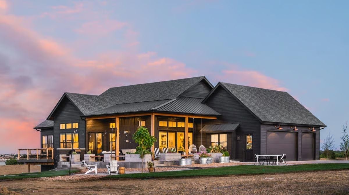 Dark Siding, Warm Light, and a Covered Porch That Pulls You Outside