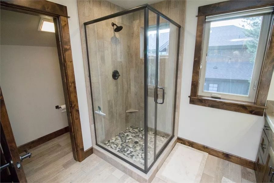 Pebble Floor and Dark Fixtures Make This Shower Worth Lingering In