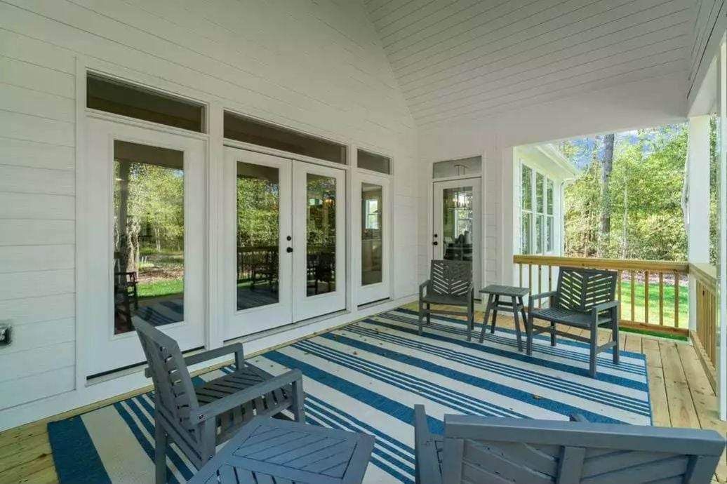 Covered Porch, French Doors, and a Striped Rug That Anchors the Whole Thing