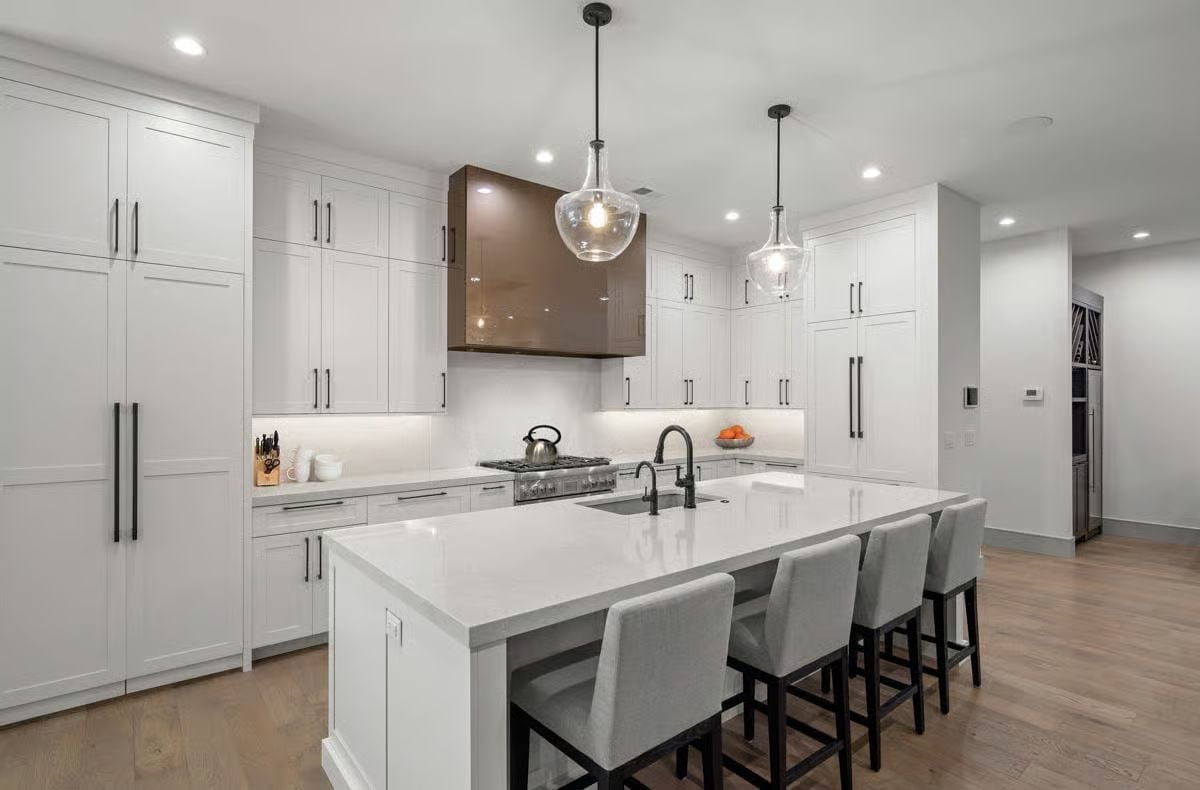 Globe Pendants and a Walnut Hood Keep This White Kitchen from Playing It Too Safe