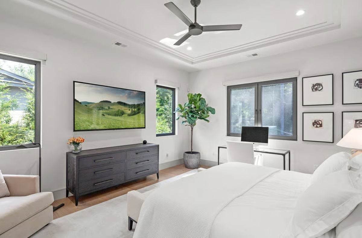 Tray Ceiling, Fiddle-Leaf Fig, and a TV Showing Green Hills Make This Bedroom Feel Like an Escape