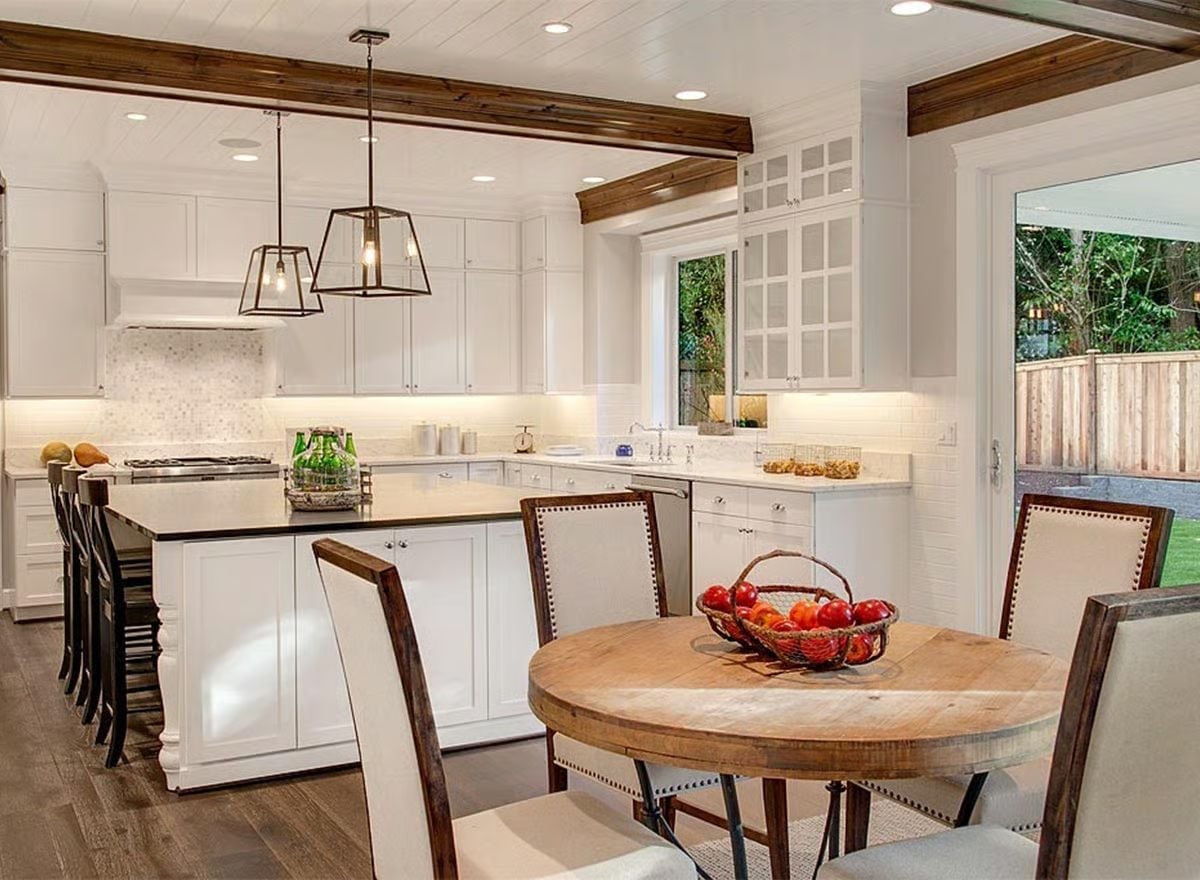 White Shaker Cabinets and Exposed Beams Pull Kitchen and Dining Into One Honest Space