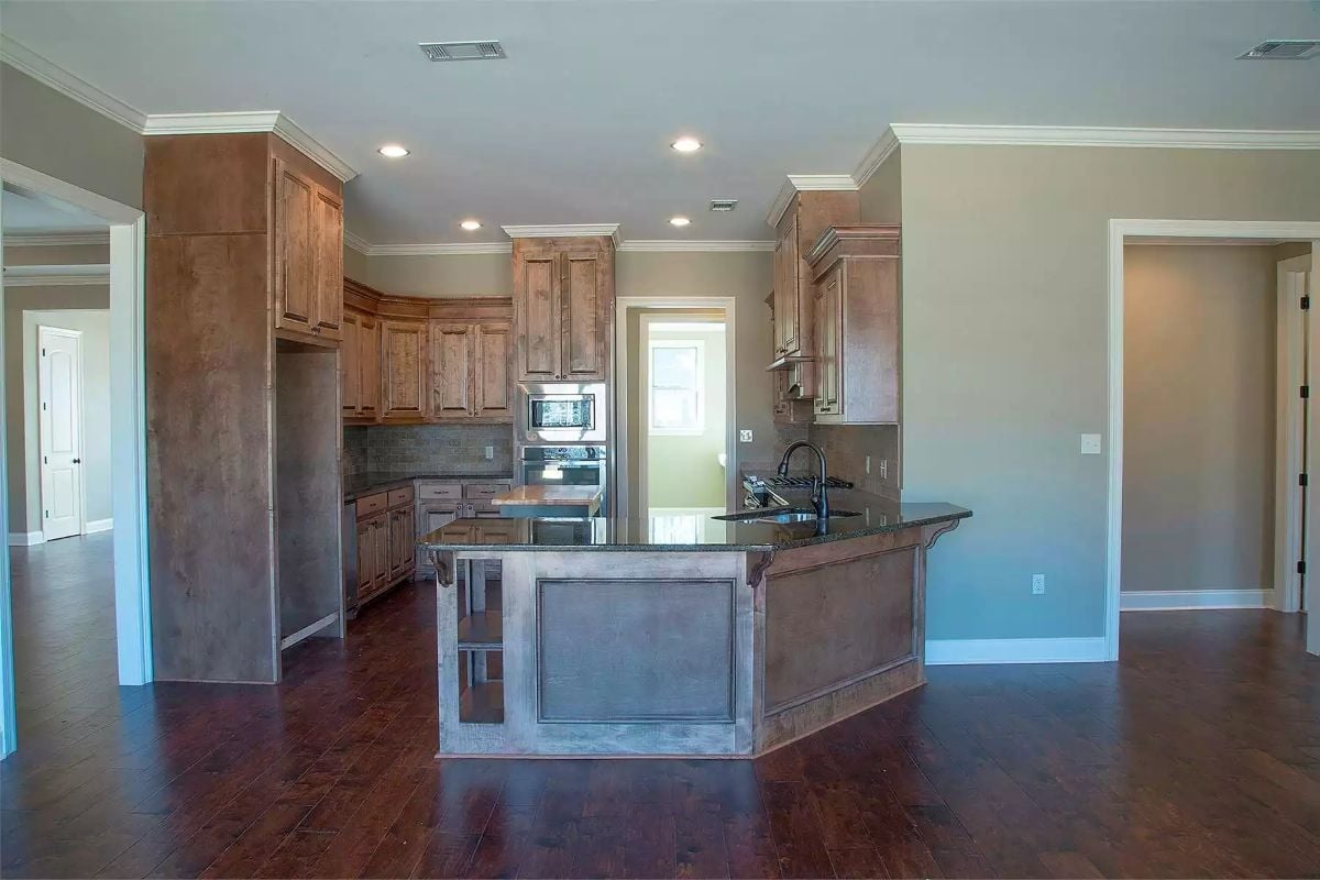 Dark Granite and Raised Panel Cabinetry in a Kitchen Built to Handle a Crowd