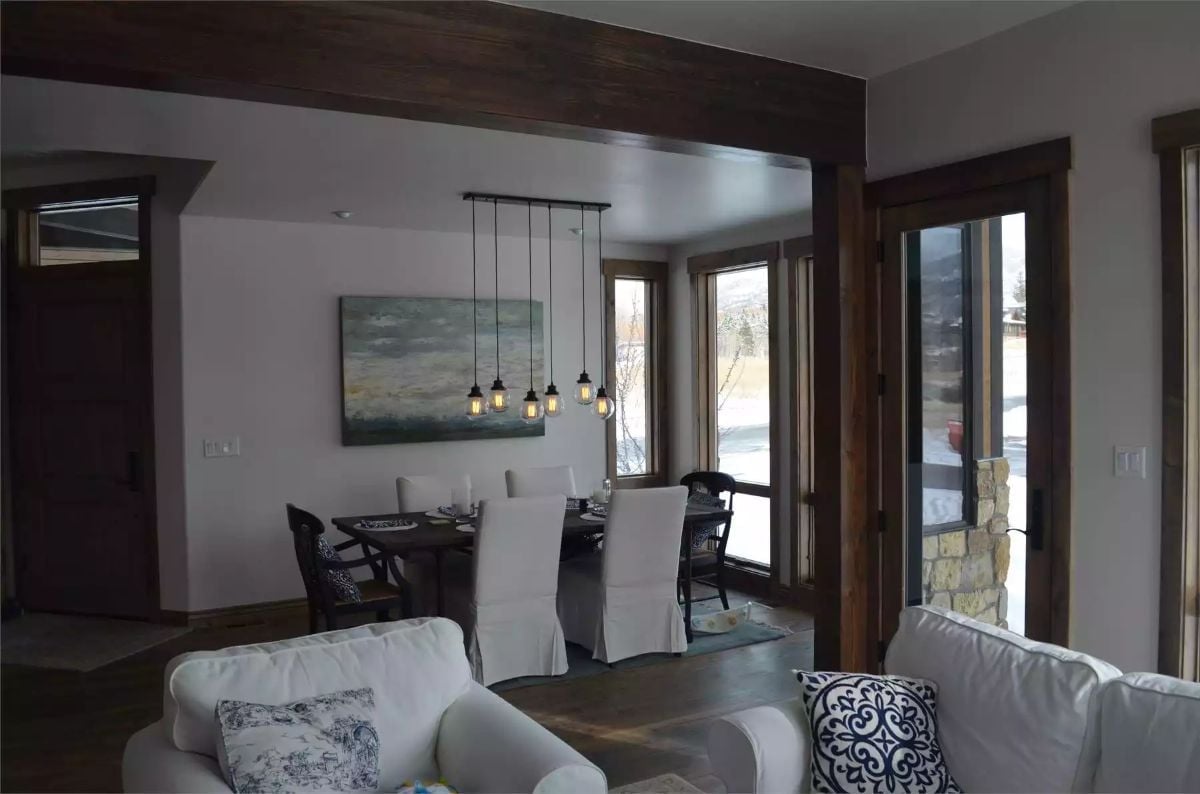 Pendant Cluster Over the Dining Table Pulls the Eye Down From Those Dark Beams