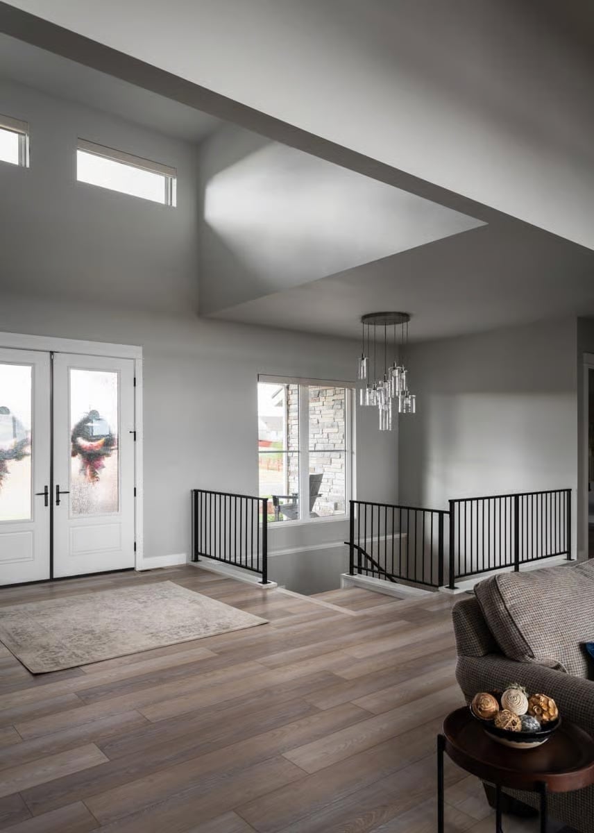Clerestory Windows and Black Iron Rails Define a Foyer Built for First Impressions