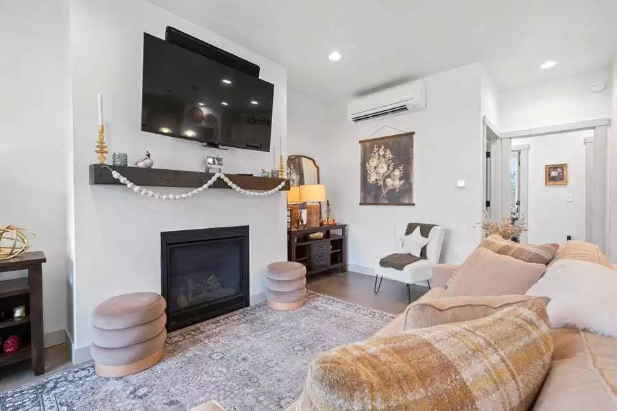 Blush Ottomans and a Real Fireplace Make This Living Room Work Harder Than It Looks