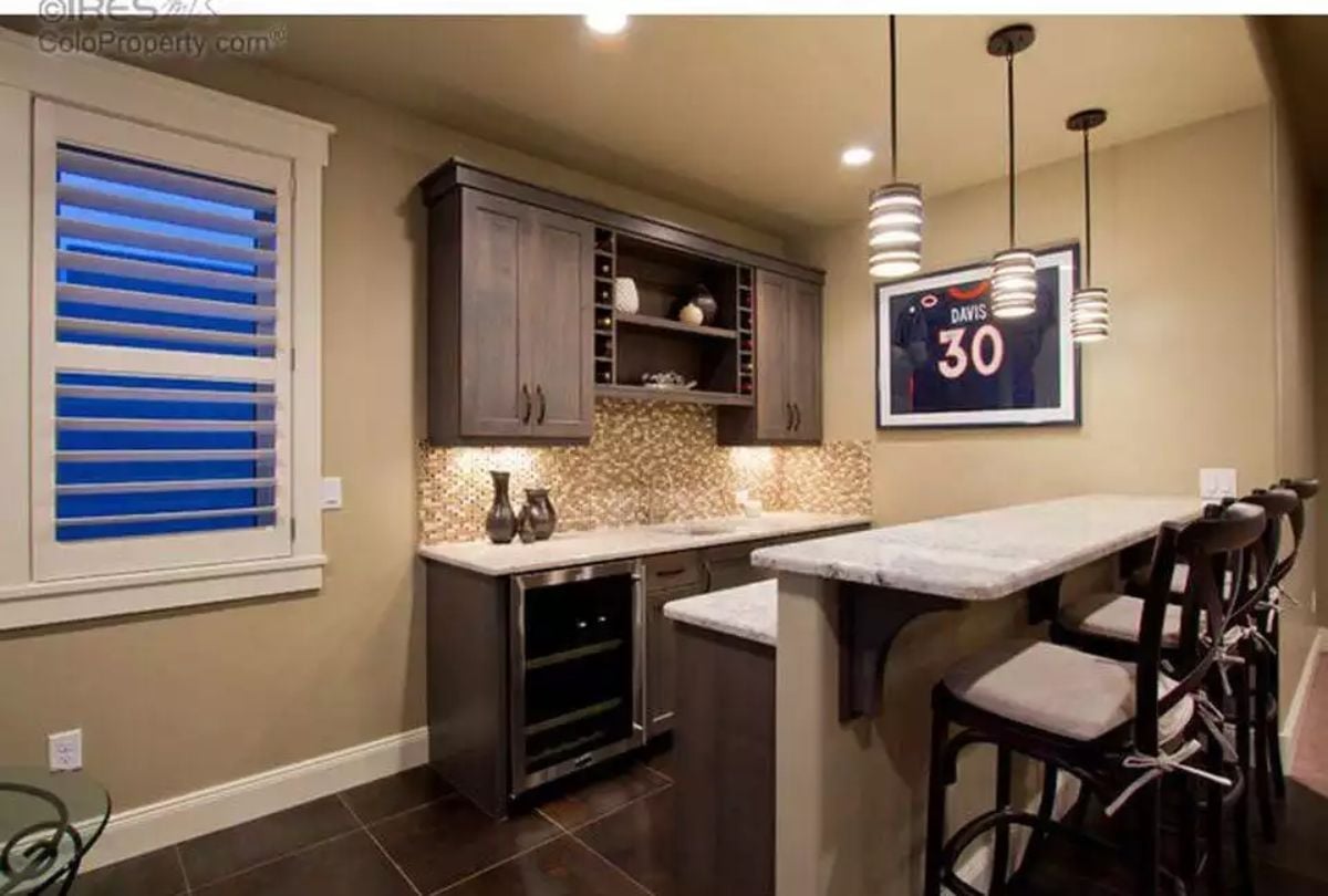 Framed Jersey, Wine Fridge, and Bar Seating That Means Business