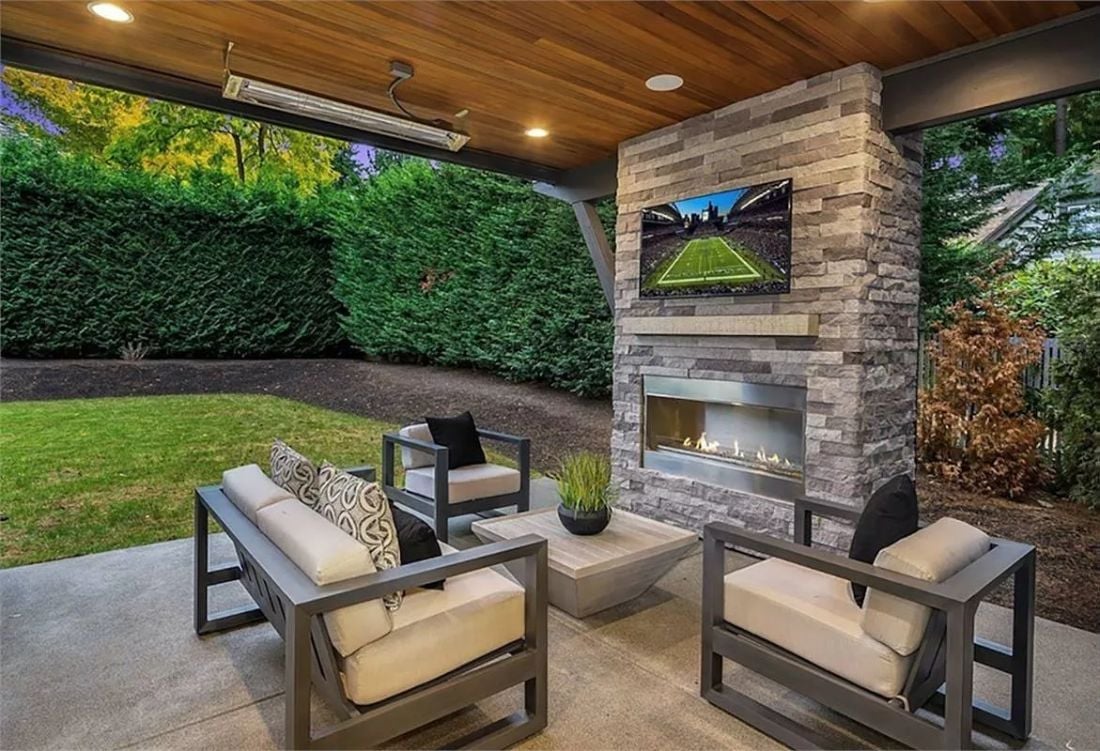 Covered Patio with a Stone Fireplace Column and an Outdoor TV Worth Staying Home For