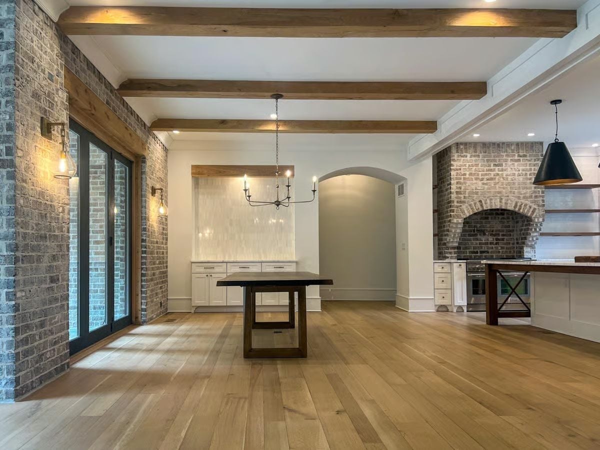 Exposed Brick and Ceiling Beams Doing the Heavy Lifting Before Furniture Arrives