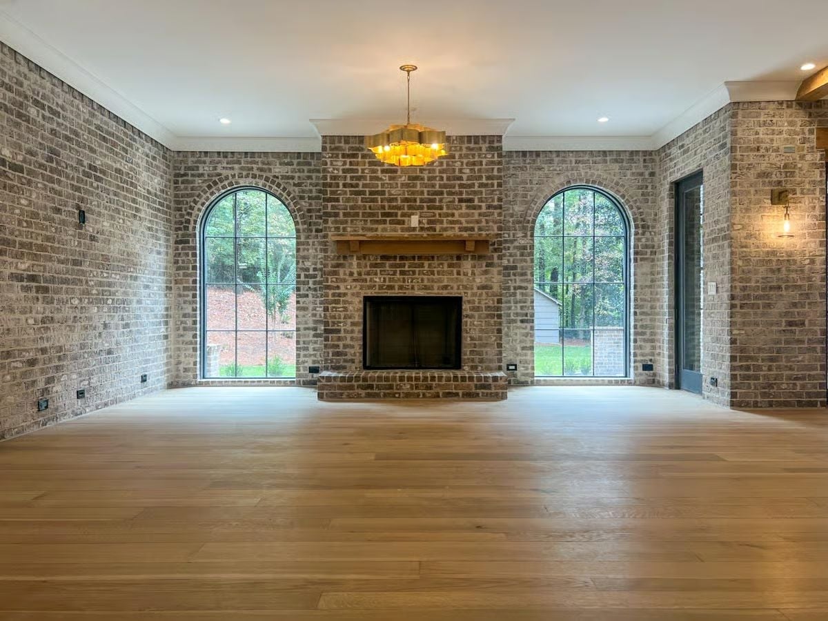 Exposed Brick on Every Wall and Arched Windows That Frame the Trees Outside