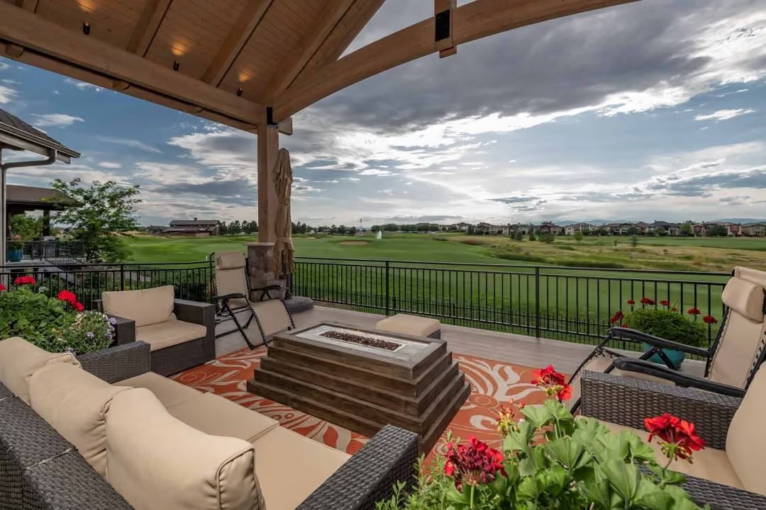 Covered Deck With a Gas Fire Table and a Golf Course That Goes On Forever