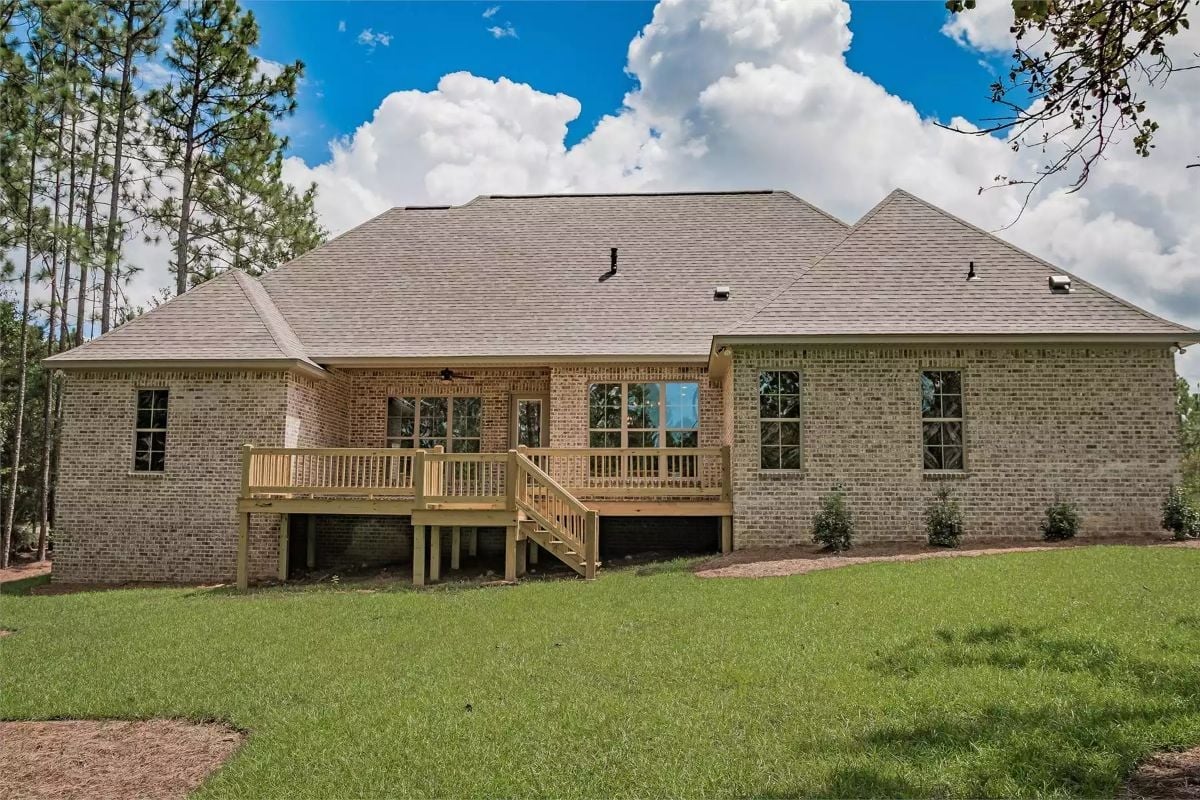 Raised Wood Deck Anchors the Back of This Brick Home to the Yard Below