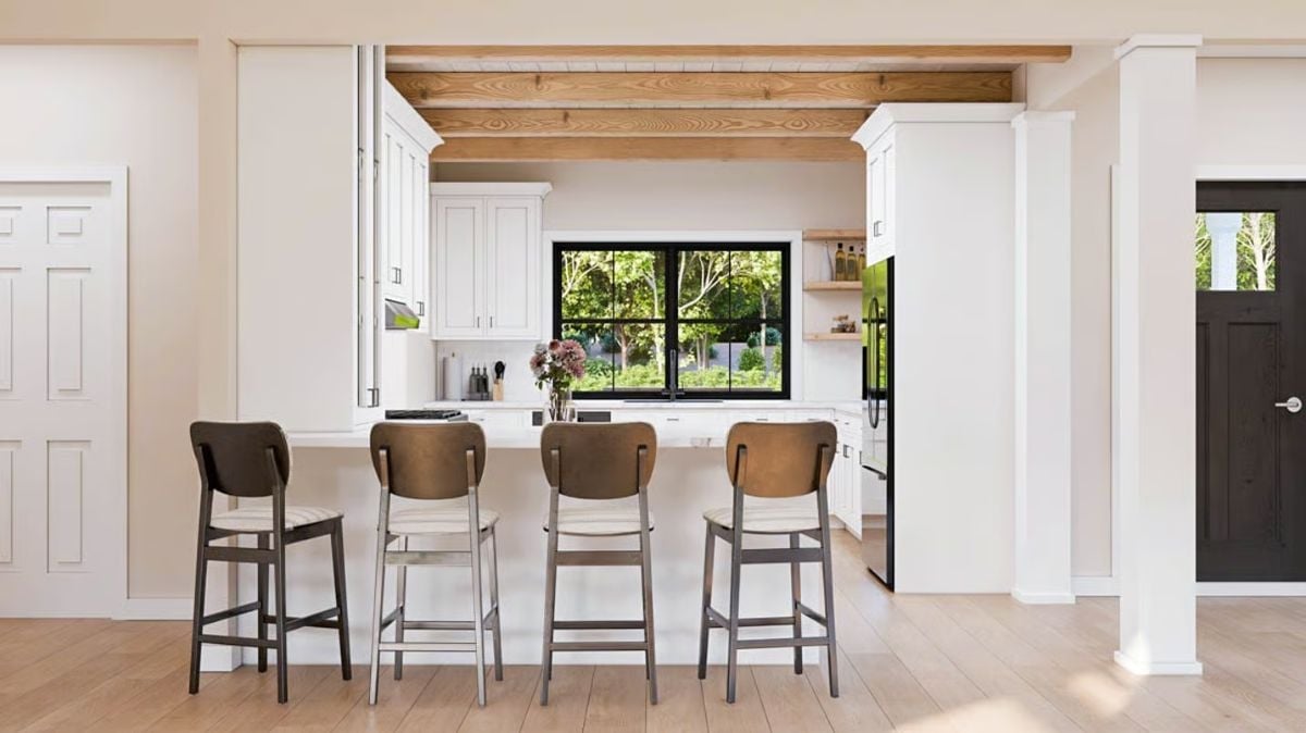 Four Barstools at a White Peninsula, Wood Beams Above, Trees Out the Window